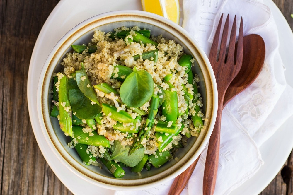 spring quinoa salad in a bowl with a wooden fork
