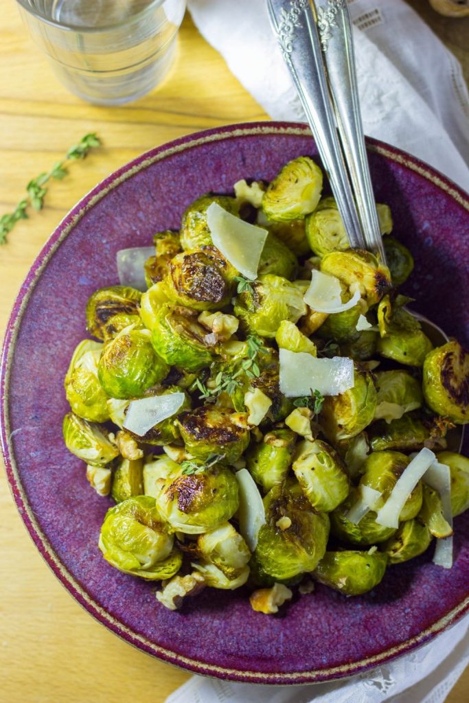 a bowl of maple dijon roasted Brussels sprouts with parmesan cheese on top