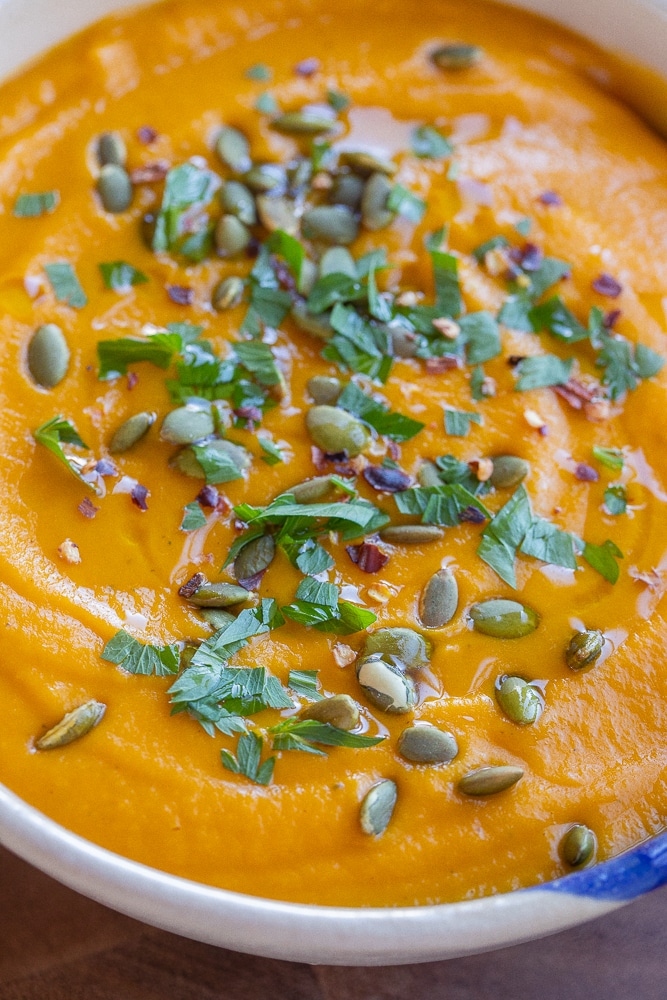 close up of a bowl of hearty vegetable soup topped with pumpkin seeds