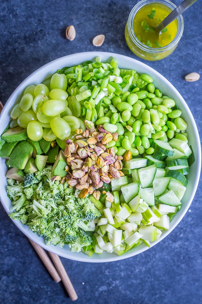 the greenest chopped salad in a big serving bowl with dressing