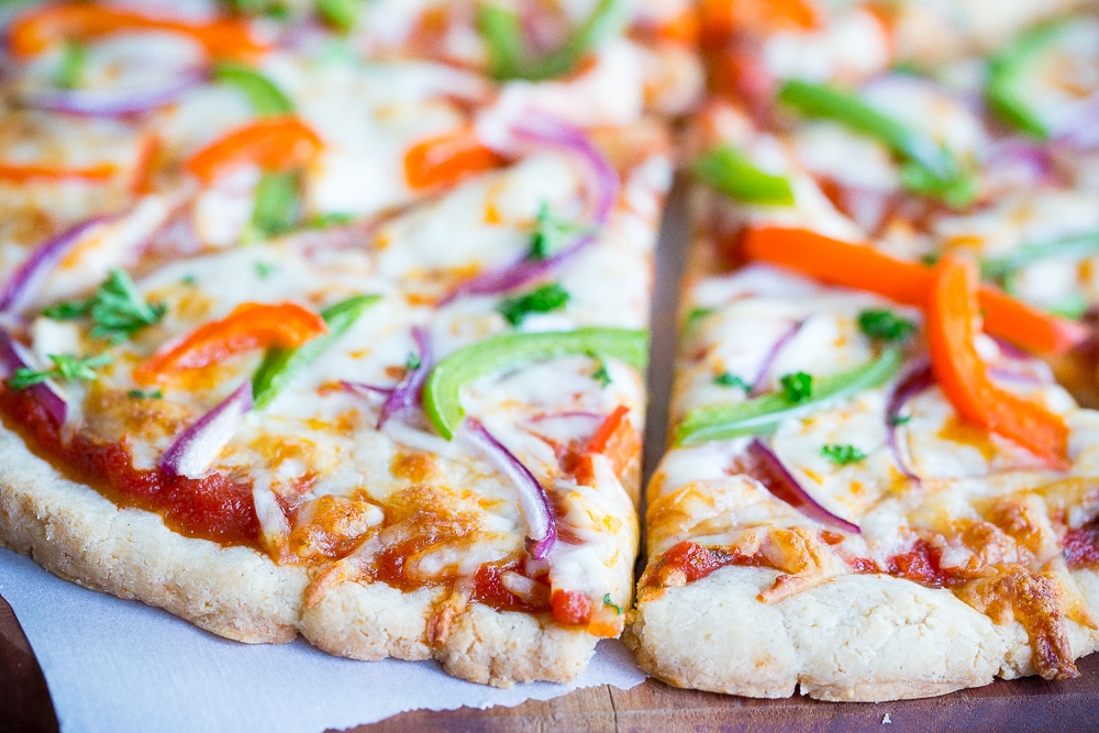 close up of gluten free pizza crust being cut into slices