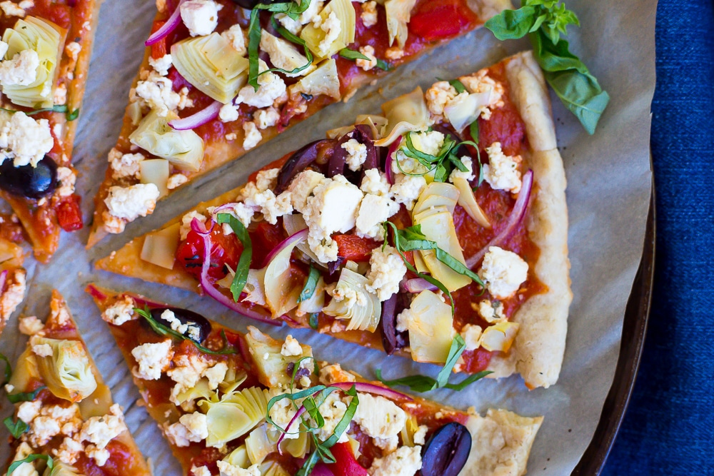This Vegan Greek Pizza is so full of delicious and fresh flavor that you won't even miss the dairy!  Vegan tofu feta adds tons of creaminess and tang!  Perfect for your next pizza night!