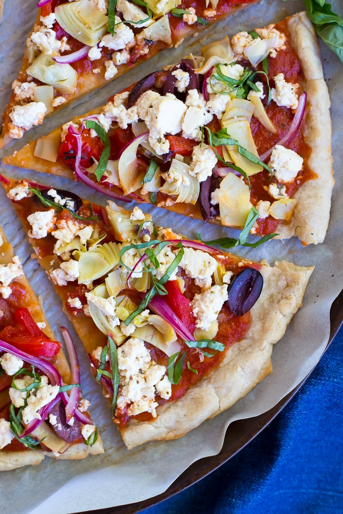 This Vegan Greek Pizza is so full of delicious and fresh flavor that you won't even miss the dairy!  Vegan tofu feta adds tons of creaminess and tang!  Perfect for your next pizza night!