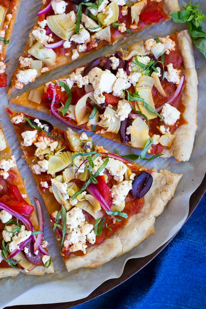 This Vegan Greek Pizza is so full of delicious and fresh flavor that you won't even miss the dairy!  Vegan tofu feta adds tons of creaminess and tang!  Perfect for your next pizza night!