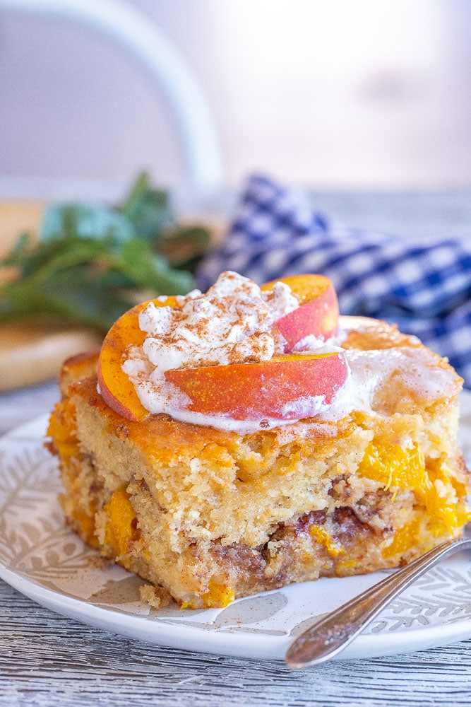 Close up of a slice of fresh peach cake with streusel filling
