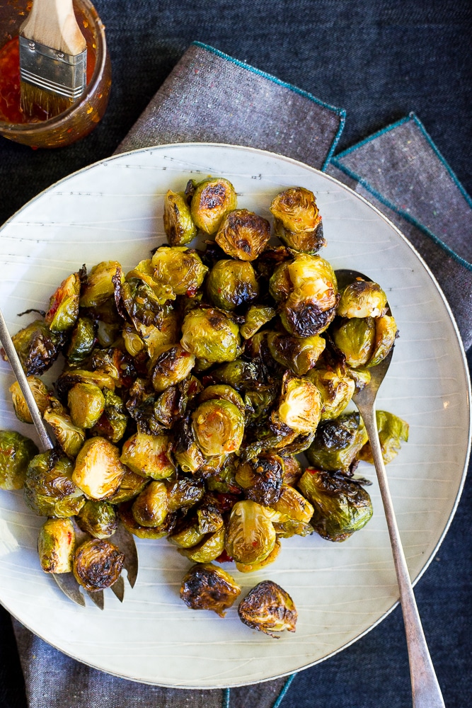 plate of sweet chili Roasted Brussels sprouts with serving utensils