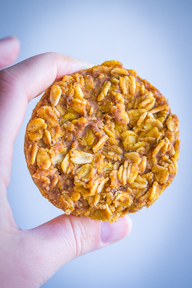 a hand holding up one pumpkin pie baked oatmeal muffin
