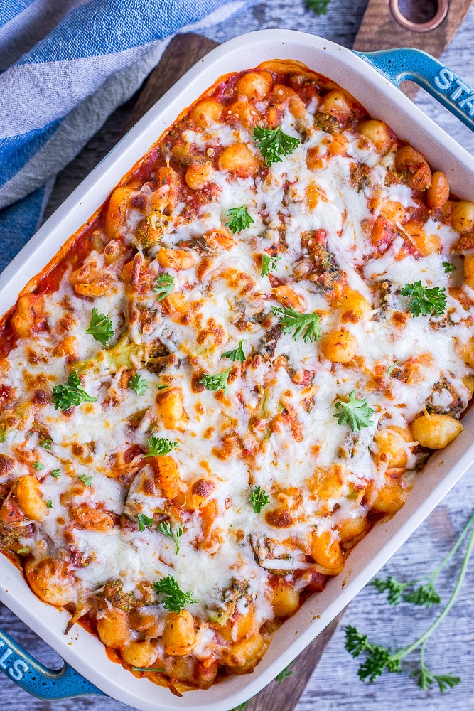 A pan of 5 Ingredient Gnocchi, Broccoli and White Bean Bake with cheese melted on top.
