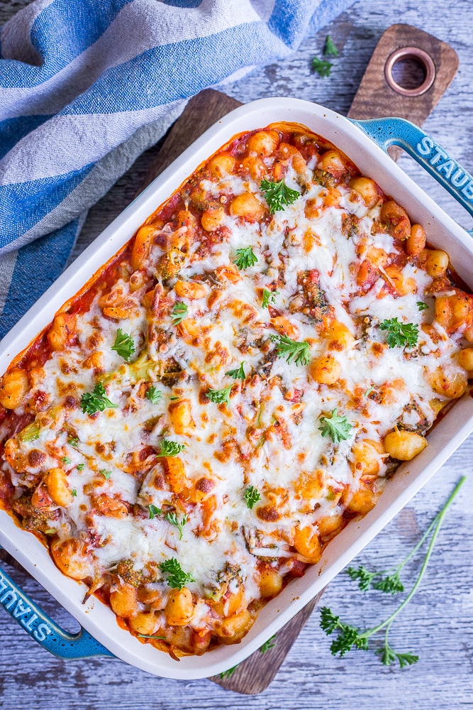 Top view of a pan of A pan of 5 Ingredient Gnocchi, Broccoli and White Bean Bake with cheese melted on top.