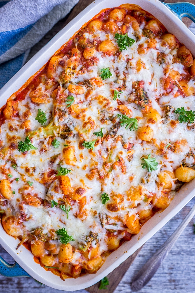 Top view of a pan of A pan of 5 Ingredient Gnocchi, Broccoli and White Bean Bake with cheese melted on top.