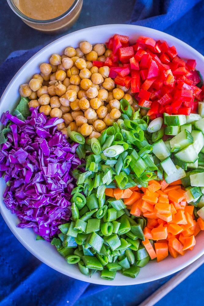 Asian Chickpea Chopped Salad in a big bowl with a napkin and jar of dressing