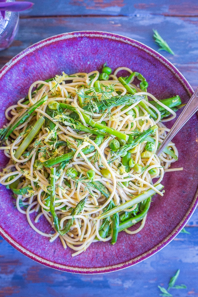 This Spring Vegetable Pasta with Lemon and Dill is so fresh and delicious! It's made with whole wheat spaghetti and packed with asparagus, peas, dill, lemon and garlic. Perfect for a quick and easy weeknight dinner! 