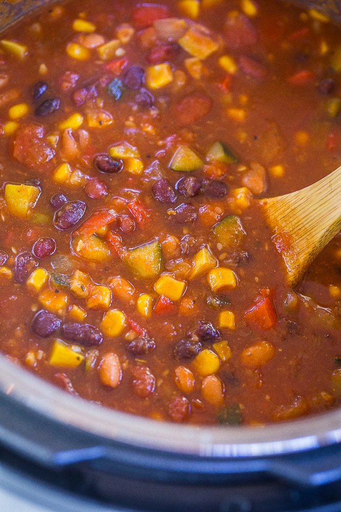 Instant Pot Vegetarian Chili in the instant pot with a wooden spoon