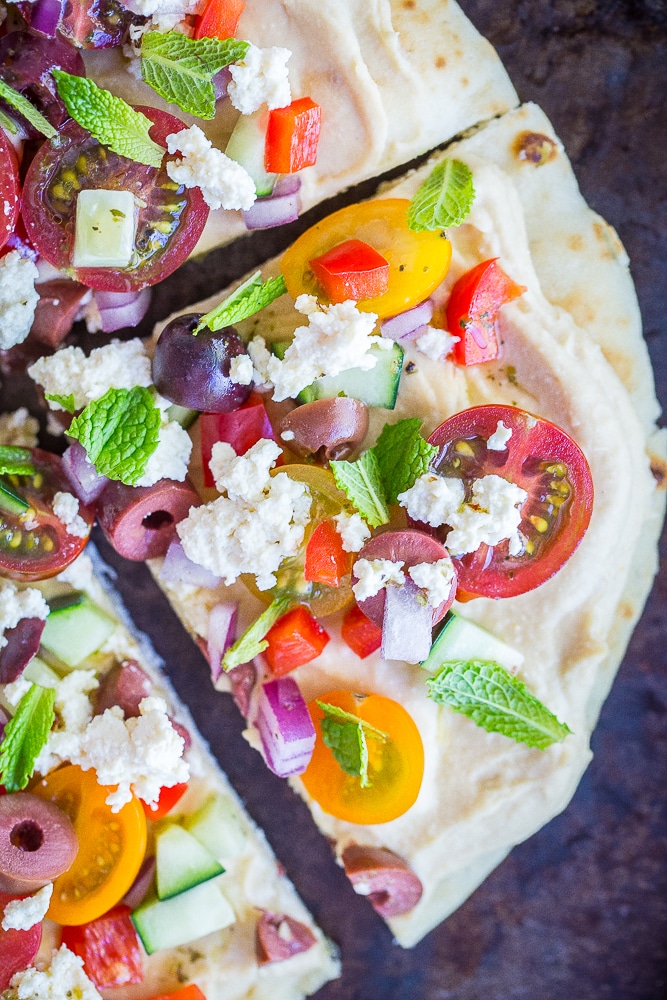 A close up of a slice of No Cook Mediterranean Hummus Pizza