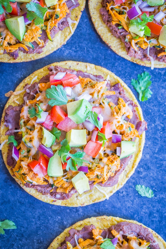 Facedown view of four 30 Minute Sweet Potato and Zucchini Tostadas on a black background