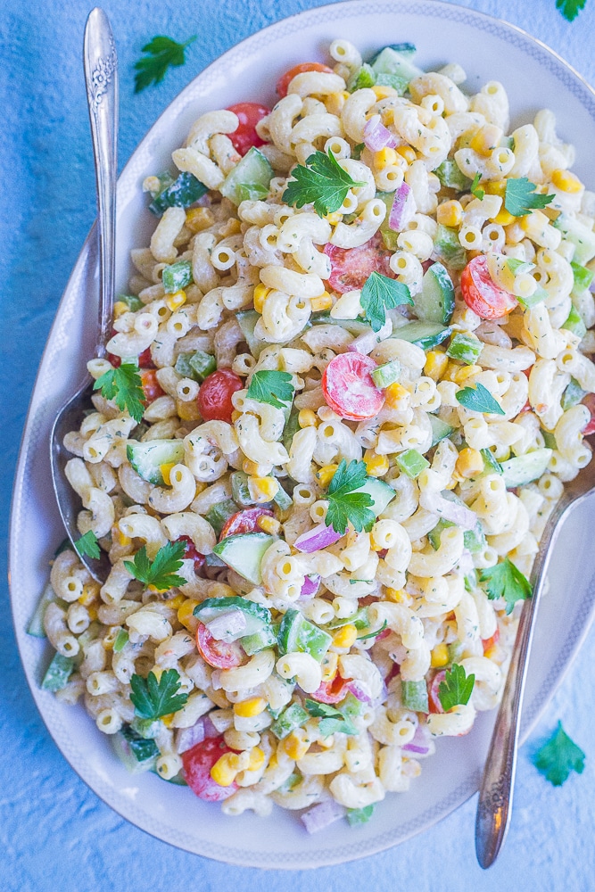 Healthier Mayo Free Macaroni Salad on a serving platter with two spoons