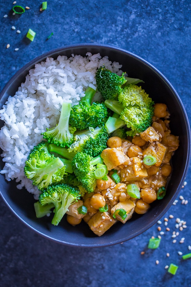 Orange Tofu Chickpea Bowls on a black background