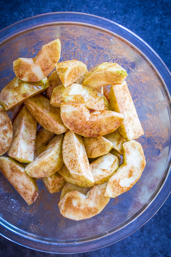 Apple slices in a bowl with cinnamon and sugar for Easy Apple Pie Bites