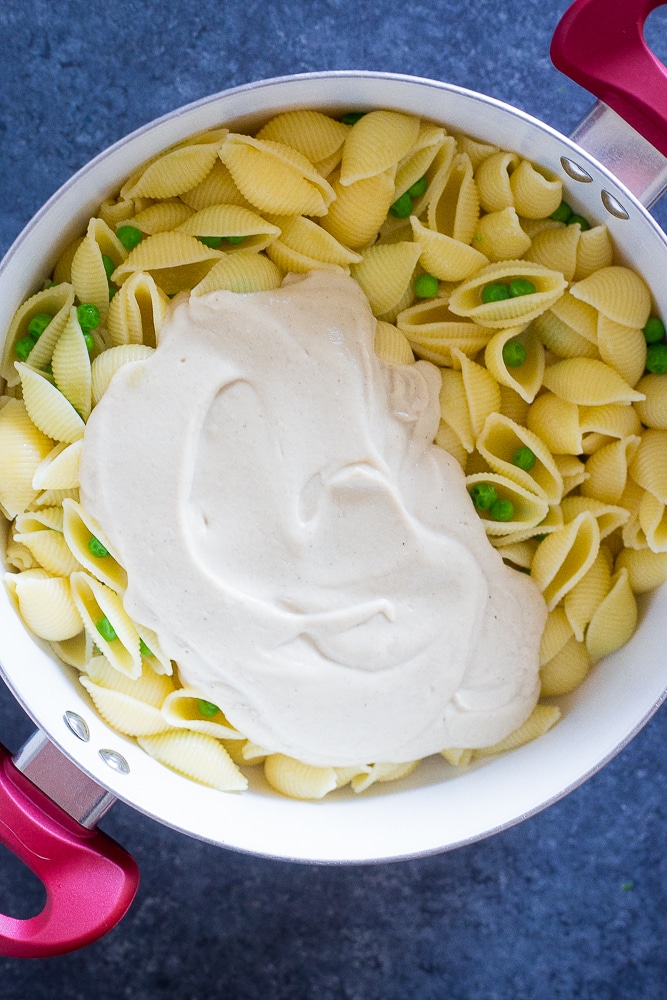 Pot of pasta with cauliflower Alfredo sauce on top for Vegan Cauliflower Alfredo with Crispy Chickpeas