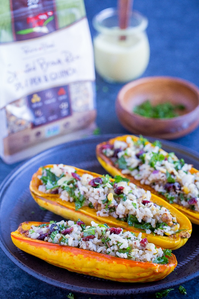 Vegetarian Stuffed Delicata Squash on a plate with ingredients in the background