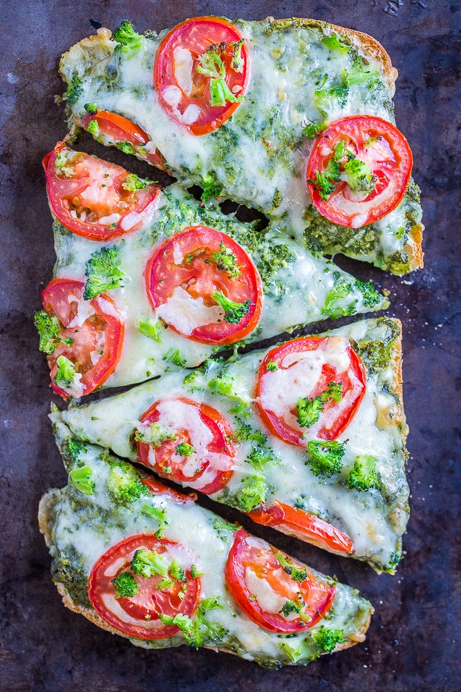 30 Minute Vegetarian French Bread Pizzas with Pesto, Tomato and Broccoli cut into slices on a sheet pan