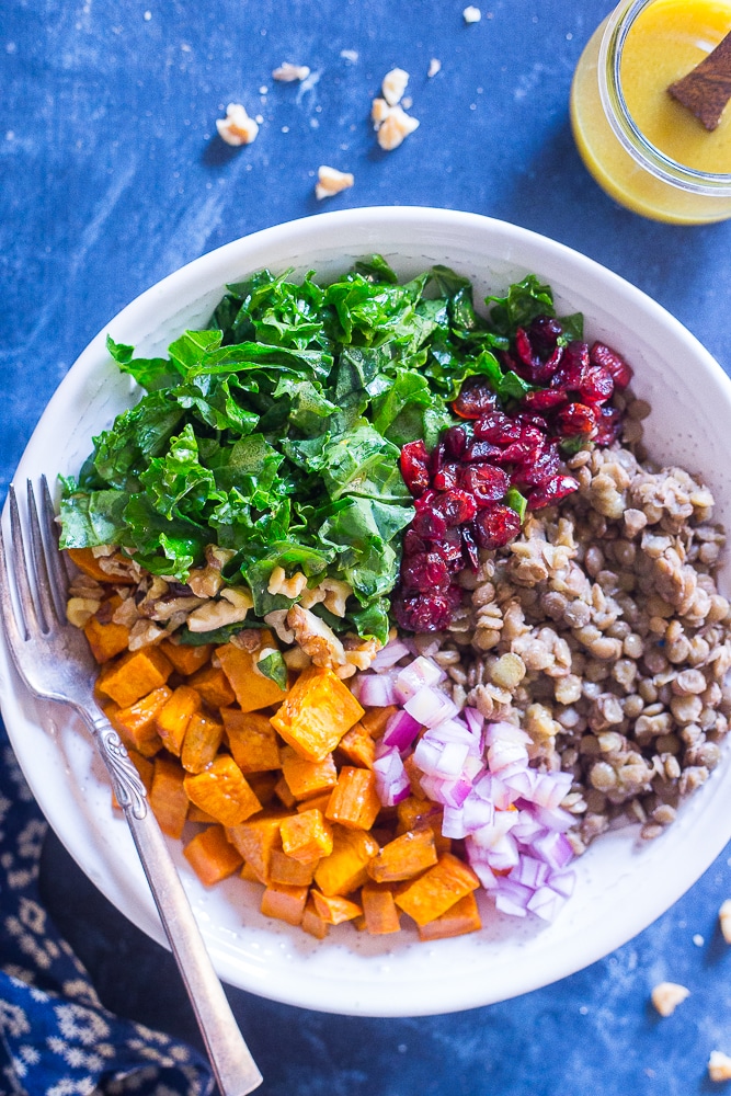 Kale Salad with Sweet Potato and Lentils in a bowl with dressing