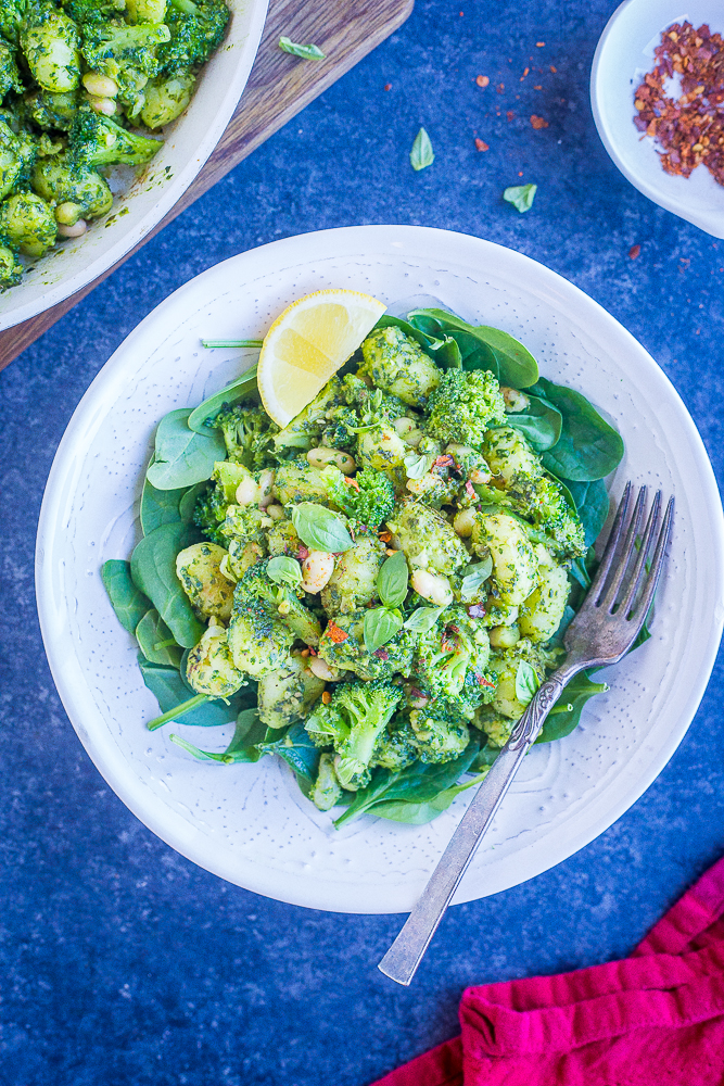 Flat lay photo of a bowl of Pesto Gnocchi with White Beans and Broccoli