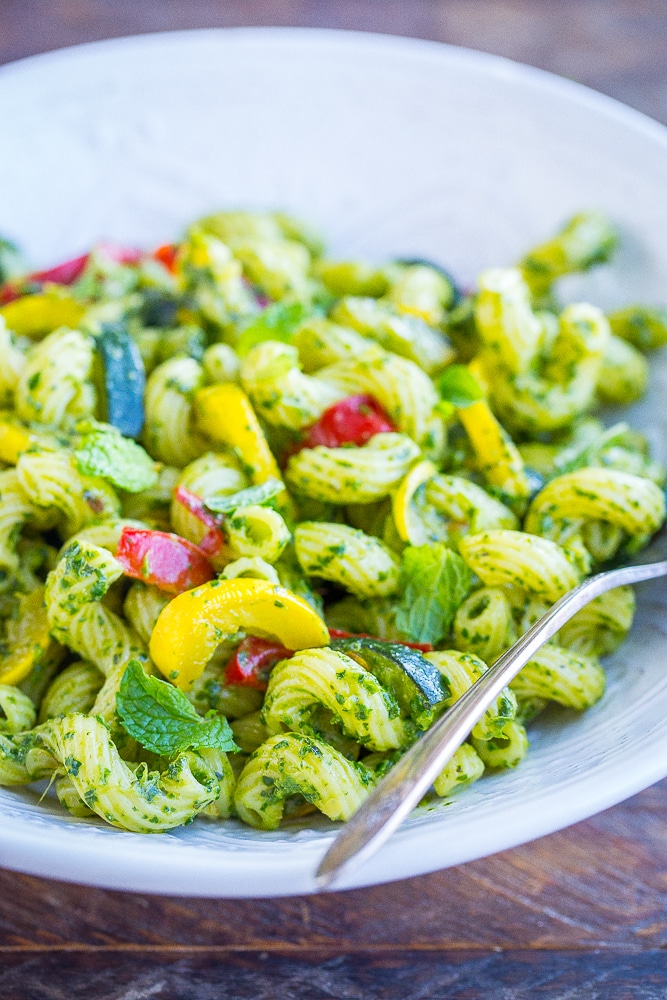 Close up view of pesto pasta with summer vegetables