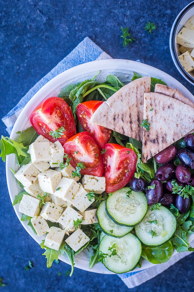 Greek salad in a white bowl with vegan feta cheese