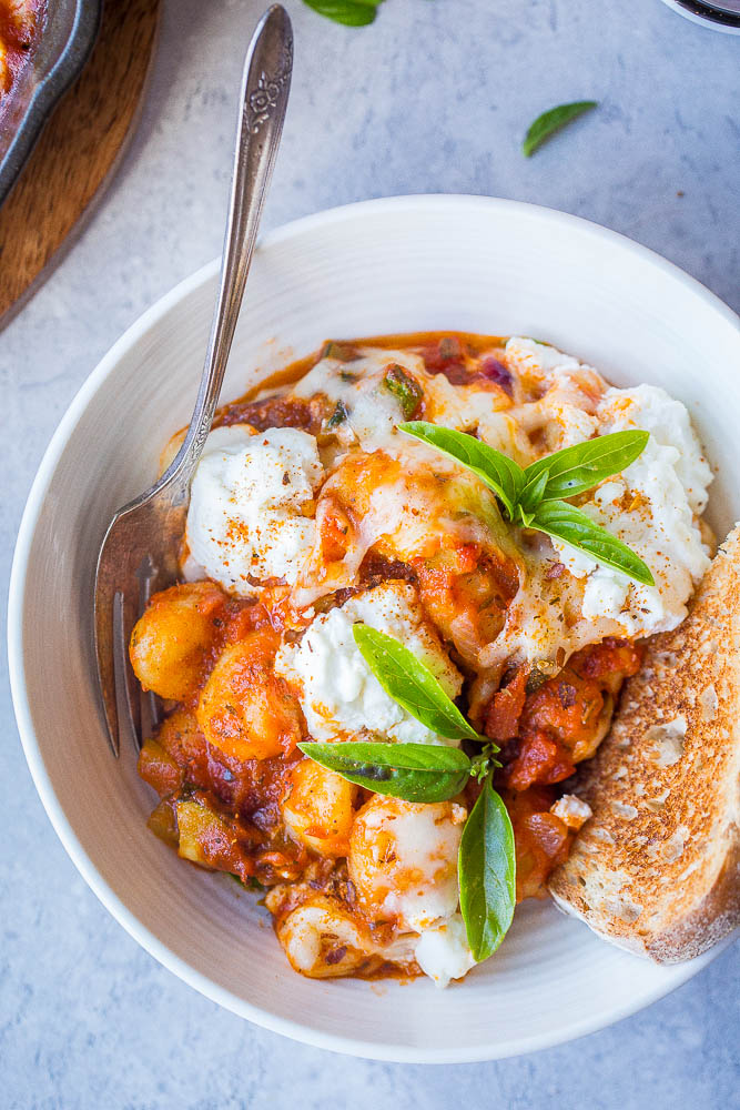 Gnocchi Lasagna Bake in a bowl with basil and bread