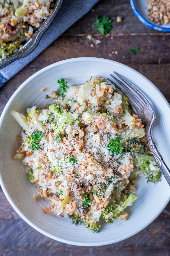 Bowl of broccoli cheese casserole recipe on a wooden table