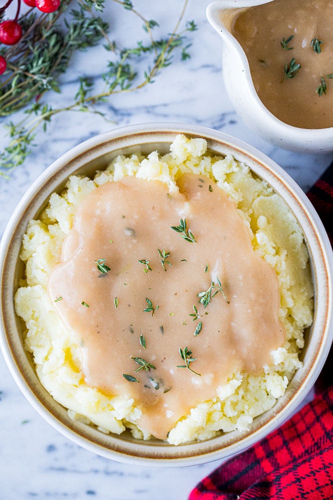 A bowl of mashed potatoes topped with gravy