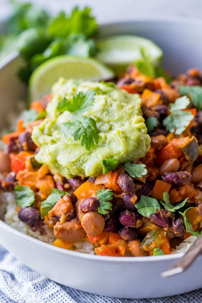 Close up of chili beans and vegetables in a bowl with guacamole