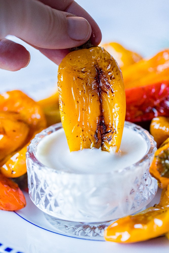 Roasted sweet pepper recipe being dipped into goat cheese sauce
