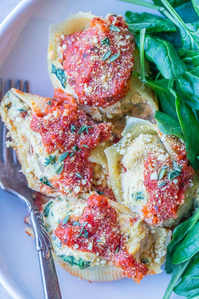 a plate of vegan stuffed shells with spinach salad