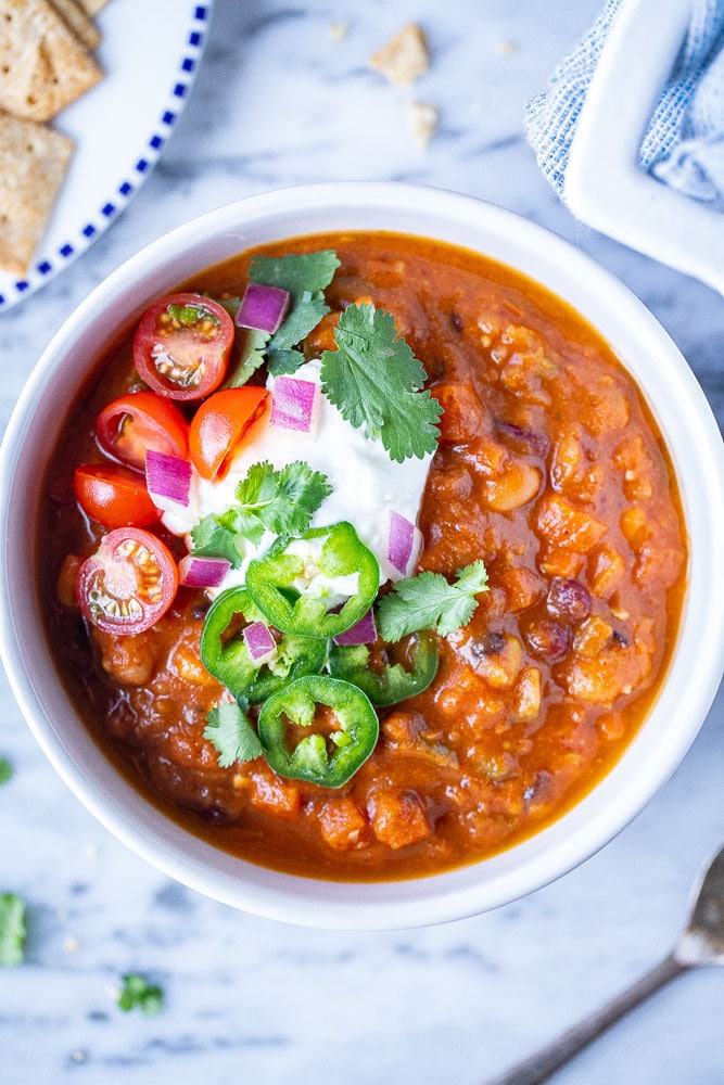 A bowl of vegetarian chili with toppings