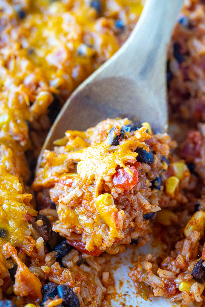 Enchilada Rice Casserole on a wooden spoon