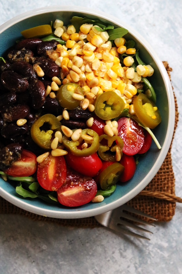 A bowl of food on a plate, with Bean and Salad