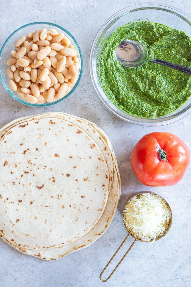 showing ingredients for these pesto quesadillas with white beans and tomato