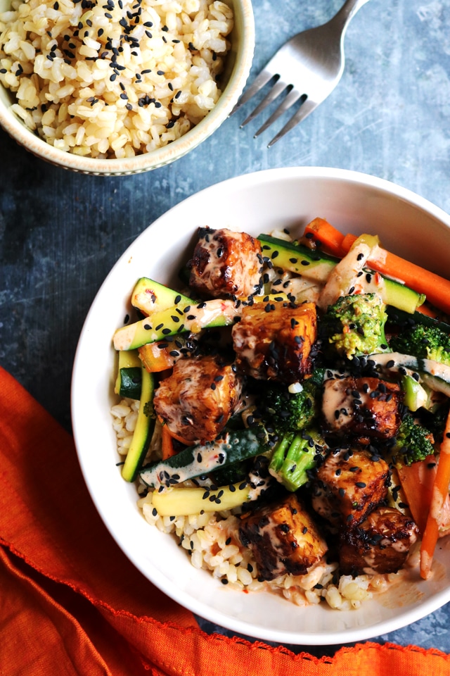 A bowl of food with rice and vegetables on a plate, with Tempeh bowls