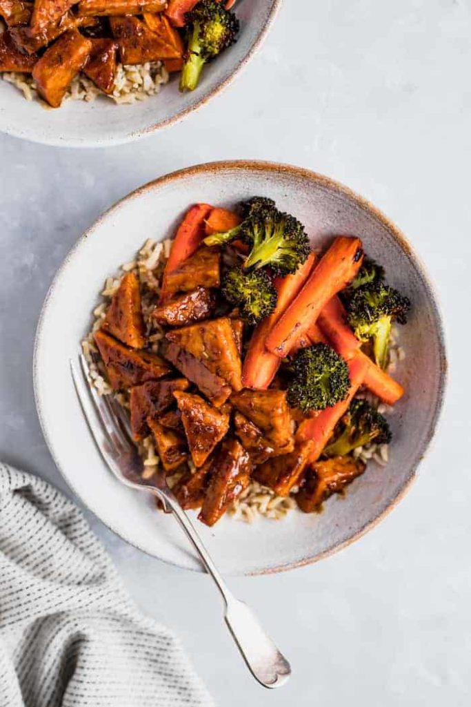 A plate of food with meat and vegetables, with Orange tempeh