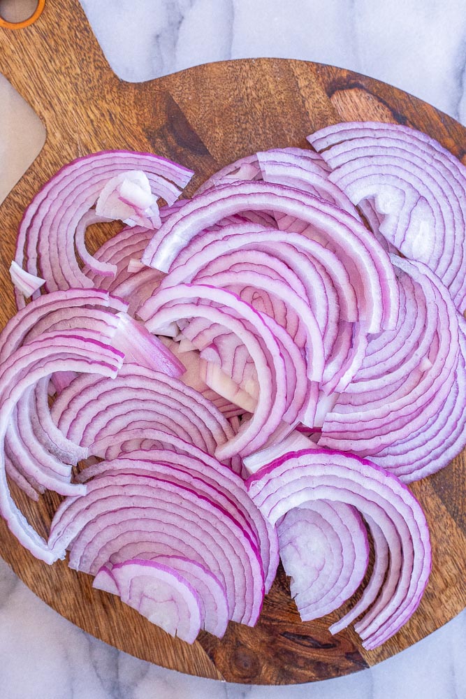 red onion sliced up on a cutting board
