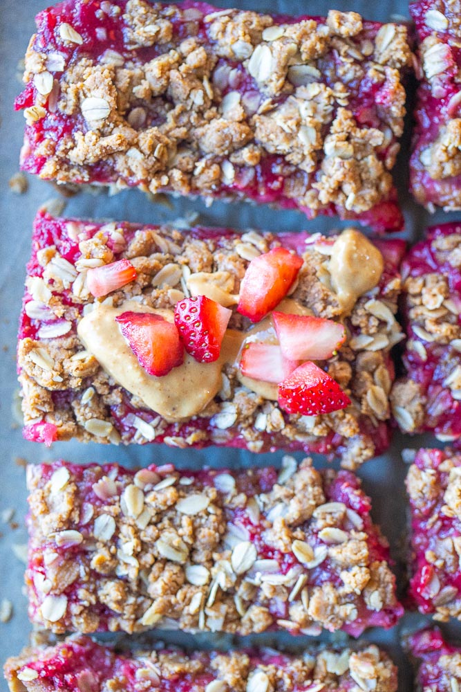 Close up of peanut butter and jelly bars with peanut butter and strawberries on top