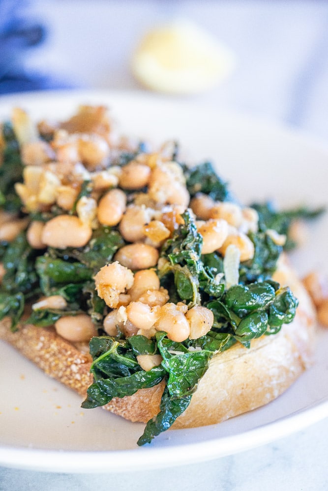 Close up of garlicky kale with white beans on toast