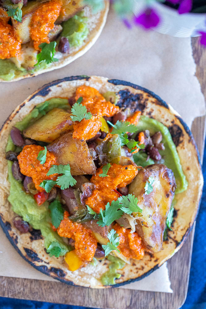 spicy potato tacos with black beans on a cutting board