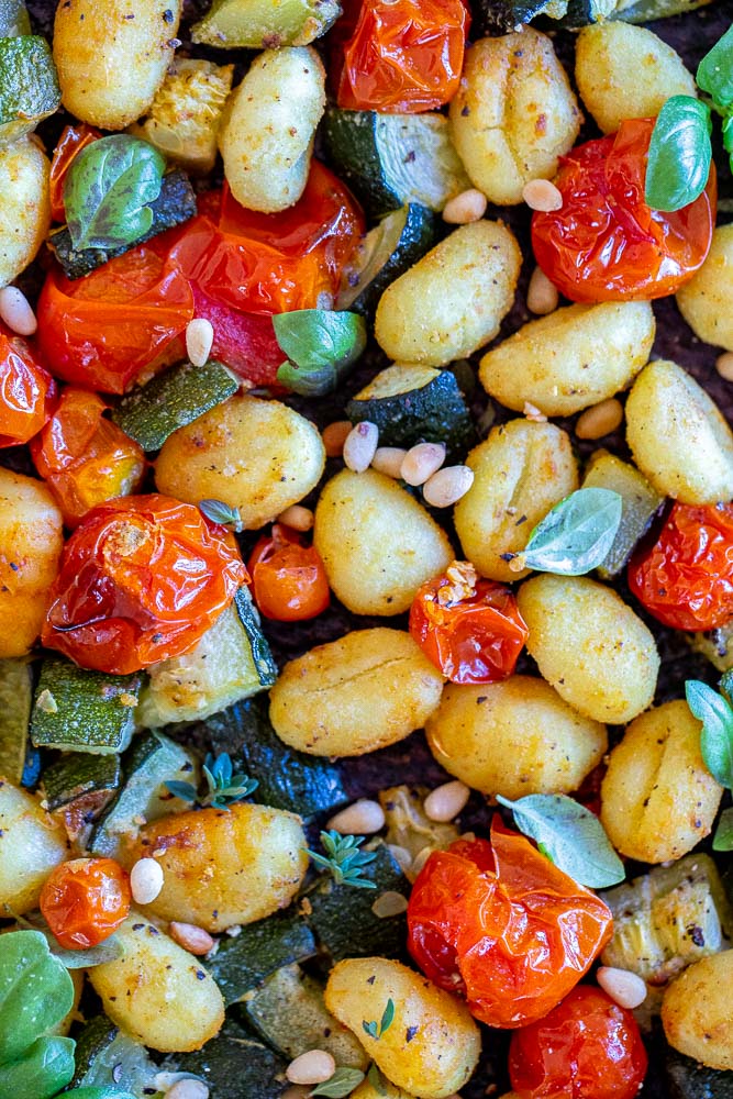 close up of sheet pan gnocchi with zucchini and cherry tomatoes