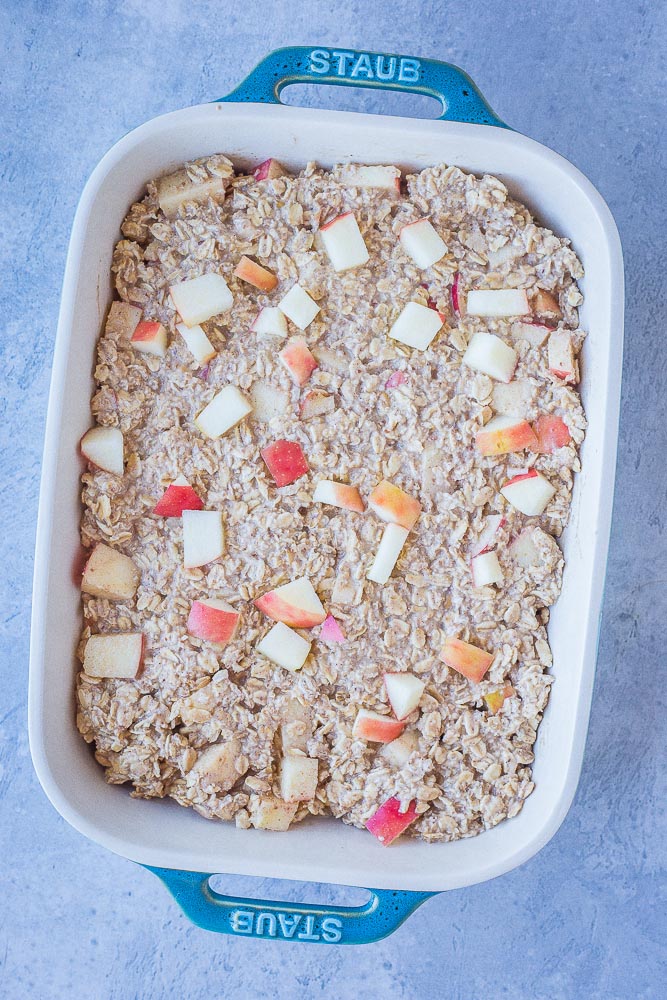 showing how to make apple cinnamon baked oatmeal in a pan before it's ready to go in the oven