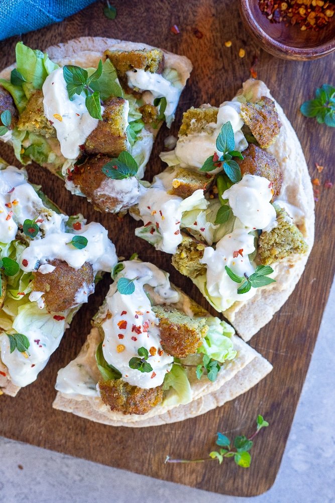 slices of an open faced falafel pita on a cutting board