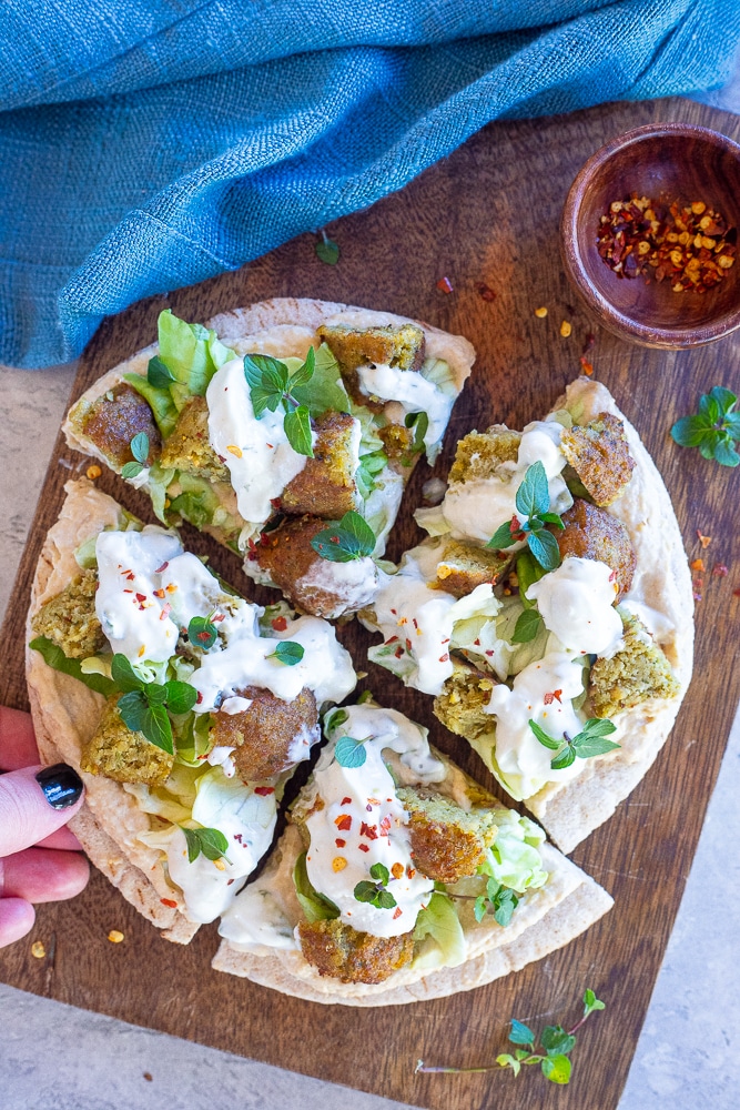 vegan falafel pita on a cutting board cut into pieces