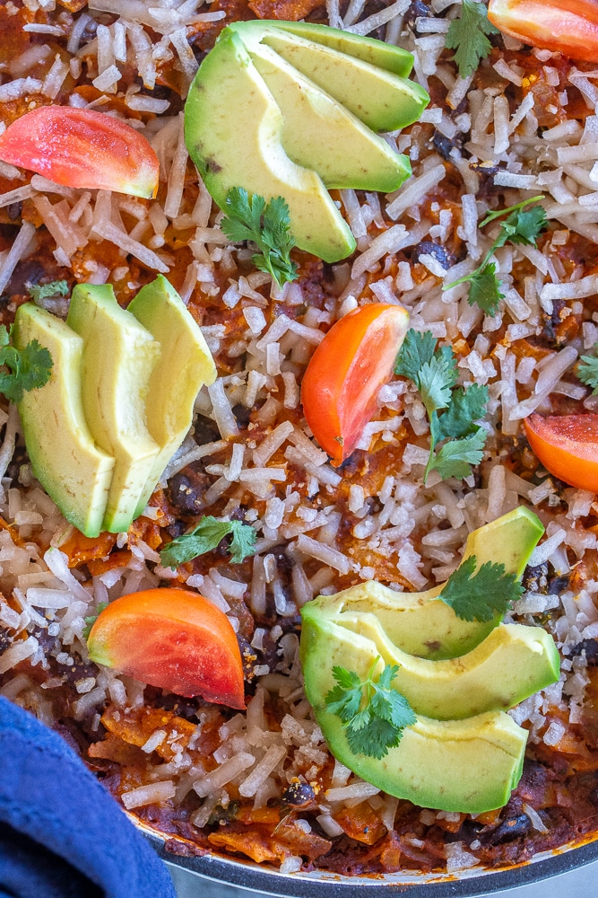 close up of skillet enchiladas with toppings